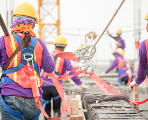 Construction workers with safety harnesses and helmets